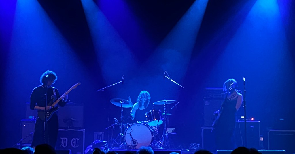 Sunflower Bean on a blue-lit stage