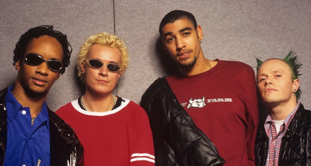 4 male members of The Prodigy, 2 wearing sunglasses, all with facial piercings